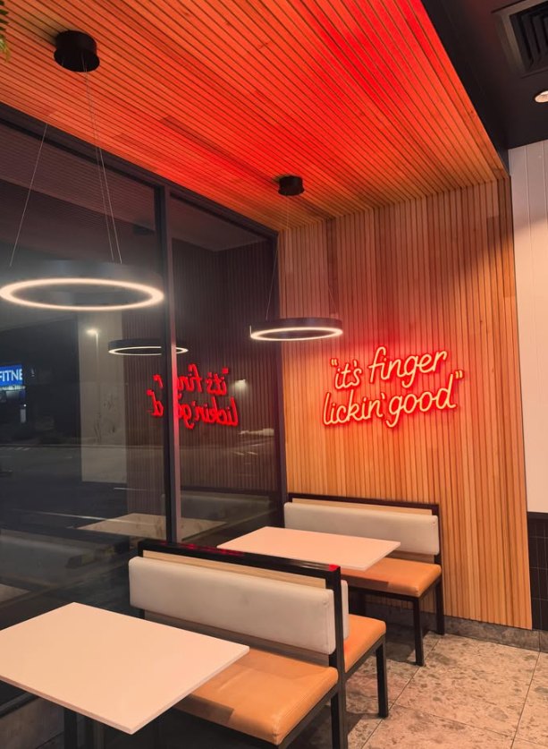 Restaurant dining area with ring pendant lights and neon sign