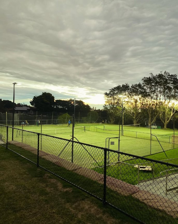 Tennis courts under new floodlighting at dusk
